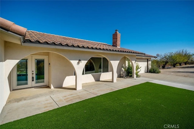 back of property featuring french doors and a garage