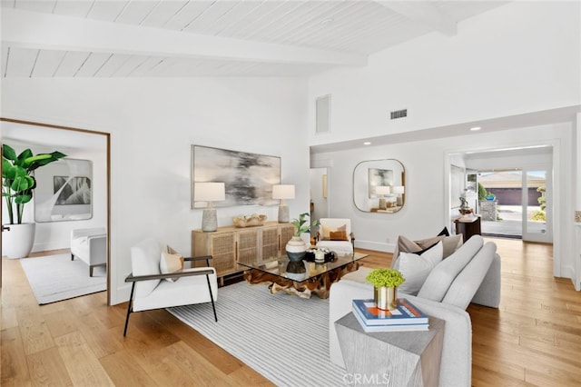 living room featuring vaulted ceiling with beams, light hardwood / wood-style flooring, and wooden ceiling