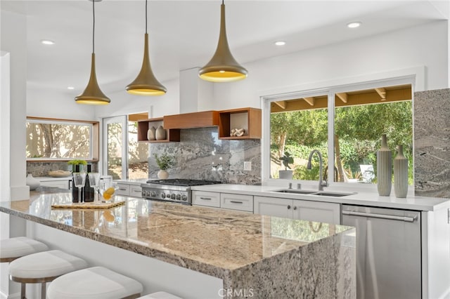 kitchen with plenty of natural light, white cabinetry, stainless steel appliances, and hanging light fixtures