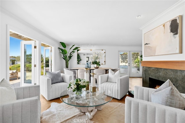 living room with plenty of natural light, light wood-type flooring, and a high end fireplace