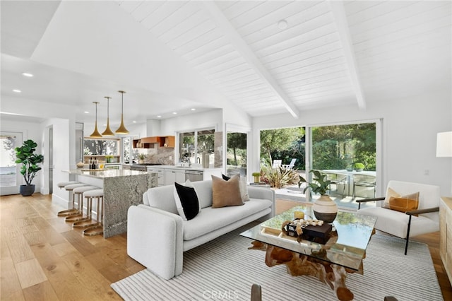 living room with beamed ceiling, light hardwood / wood-style floors, and high vaulted ceiling