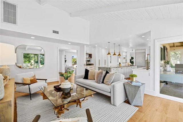 living room featuring beam ceiling, wooden ceiling, high vaulted ceiling, and light hardwood / wood-style flooring