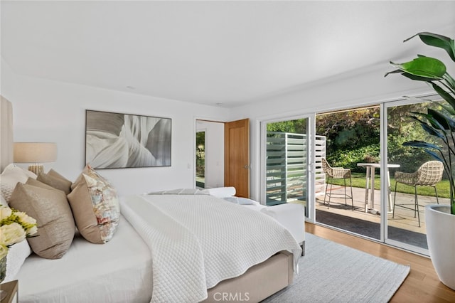 bedroom featuring access to exterior and light hardwood / wood-style flooring