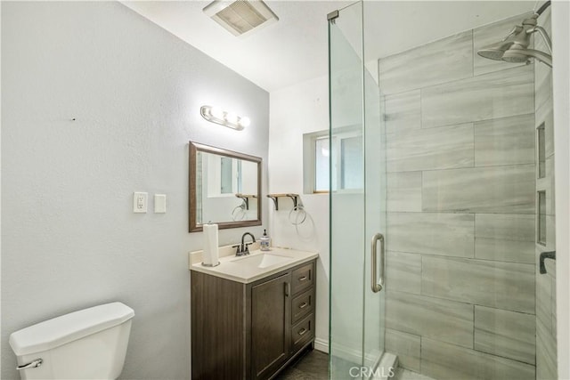 bathroom featuring walk in shower, vanity, and toilet