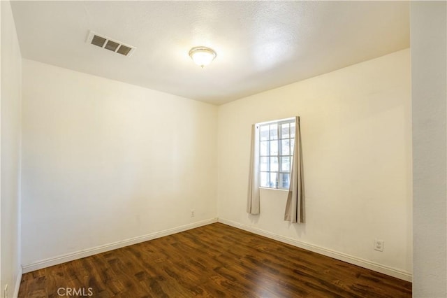 empty room with dark hardwood / wood-style flooring