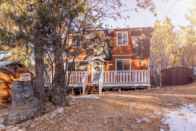 view of front of home with a storage unit and a deck