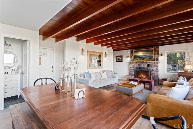 living room with beamed ceiling, wooden ceiling, and light wood-type flooring