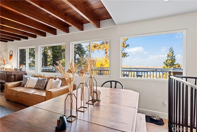 sunroom with beam ceiling, a wealth of natural light, a water view, and wood ceiling