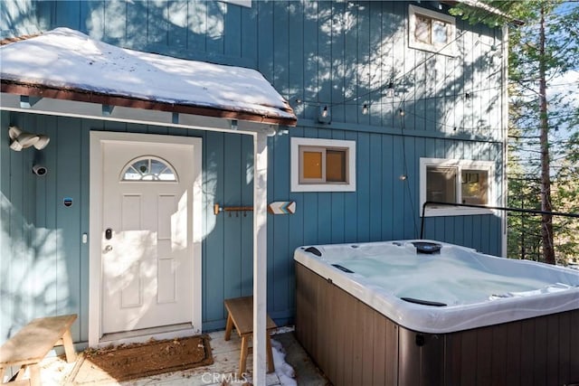 property entrance with a hot tub