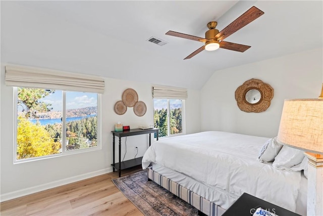 bedroom with ceiling fan, vaulted ceiling, light hardwood / wood-style flooring, and multiple windows