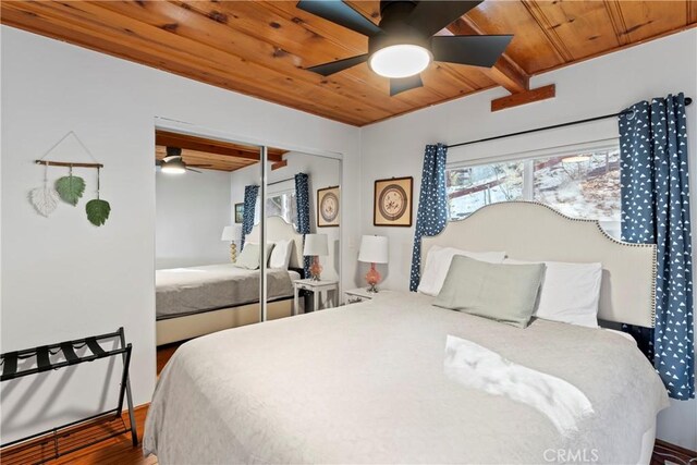 bedroom featuring ceiling fan, wood ceiling, dark wood-type flooring, and a closet