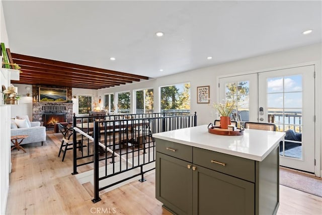 kitchen featuring a fireplace, light wood-type flooring, a kitchen island, and gray cabinetry