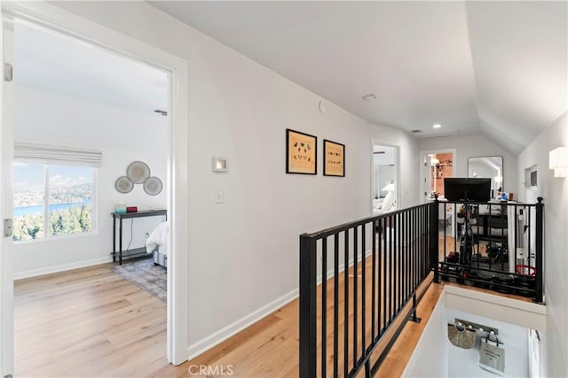 corridor featuring vaulted ceiling and light hardwood / wood-style flooring