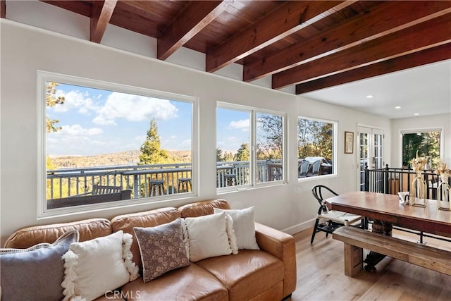 sunroom / solarium with beam ceiling, a mountain view, french doors, and wooden ceiling