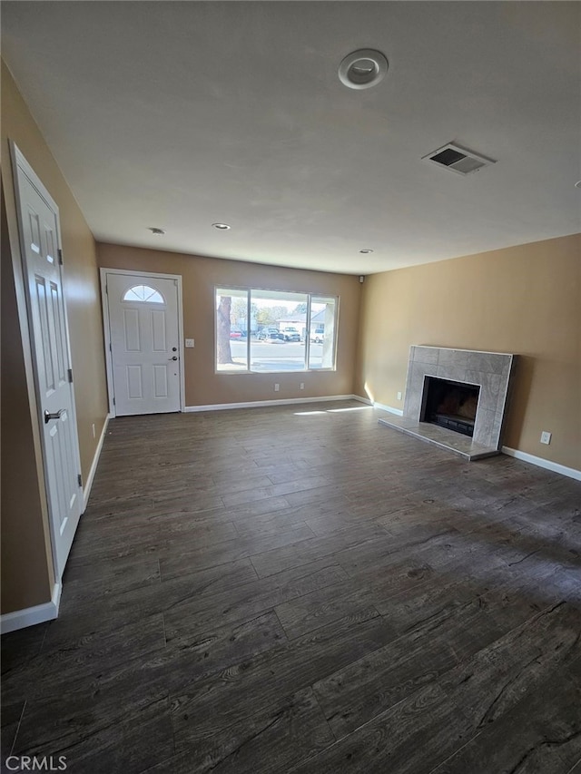 unfurnished living room with a fireplace and dark wood-type flooring