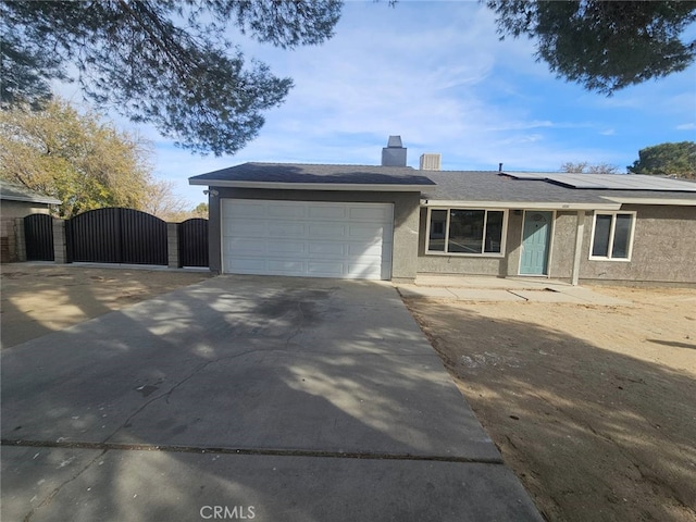 ranch-style house featuring solar panels and a garage