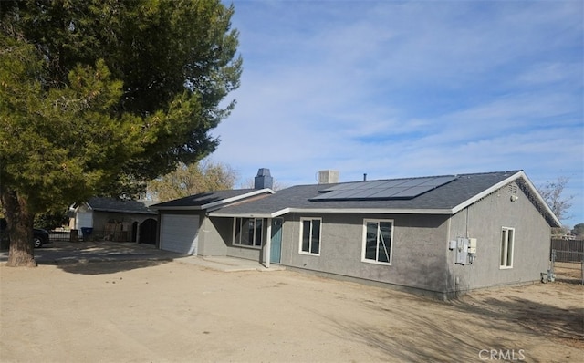 ranch-style house featuring solar panels and a garage