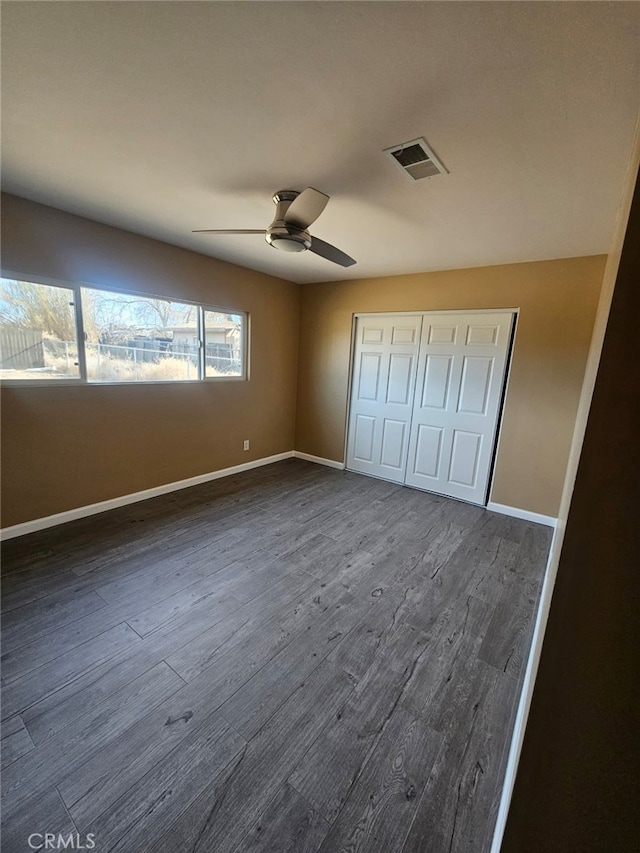 unfurnished bedroom with a closet, ceiling fan, and dark hardwood / wood-style flooring