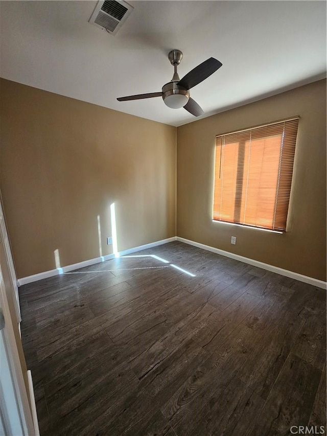 empty room with ceiling fan and dark hardwood / wood-style flooring