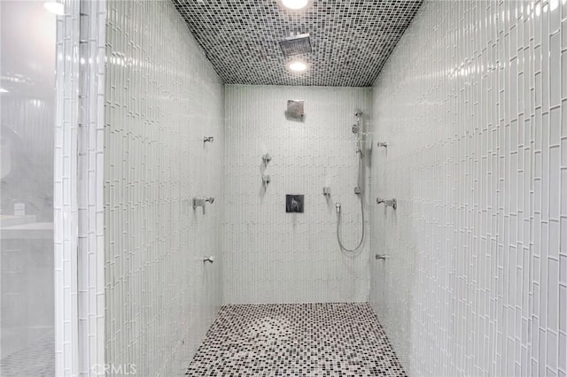 bathroom featuring tile walls and tiled shower