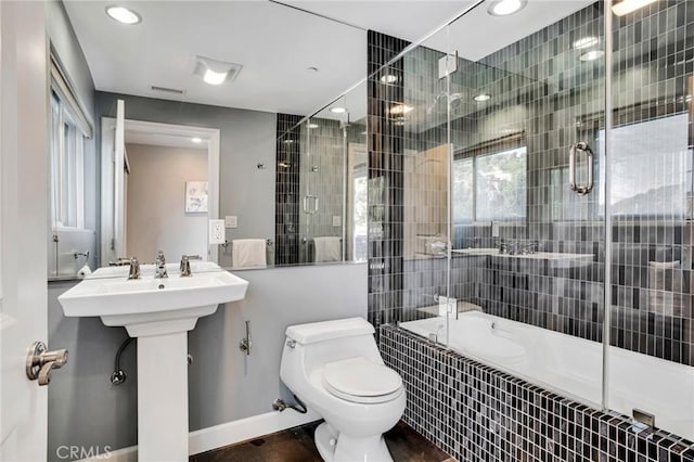 full bathroom featuring sink, enclosed tub / shower combo, and toilet