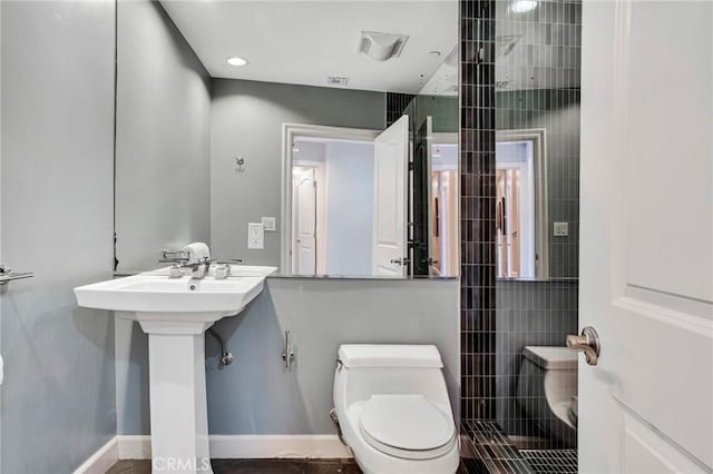 bathroom featuring sink, toilet, and a shower