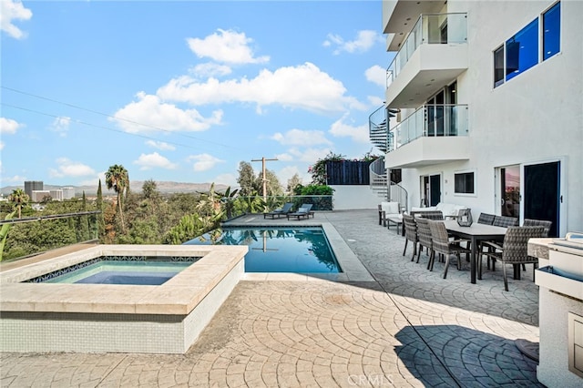 view of swimming pool featuring a patio area and an in ground hot tub