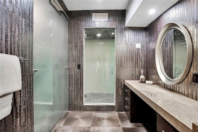 bathroom featuring vanity, tile walls, and a shower with shower door