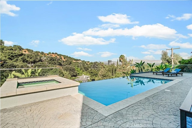 view of pool with a patio area and an in ground hot tub