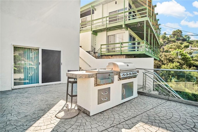 view of patio / terrace featuring a grill, a bar, and exterior kitchen