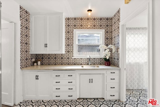 kitchen with white cabinetry, sink, and tasteful backsplash