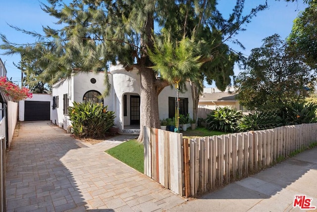 mediterranean / spanish-style home featuring a garage and an outdoor structure