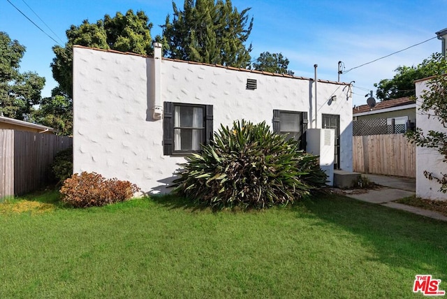 view of side of home featuring a lawn