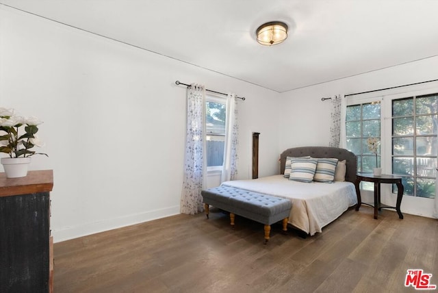 bedroom with dark hardwood / wood-style flooring