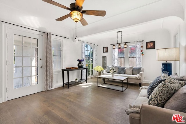 living room with ceiling fan with notable chandelier and hardwood / wood-style flooring