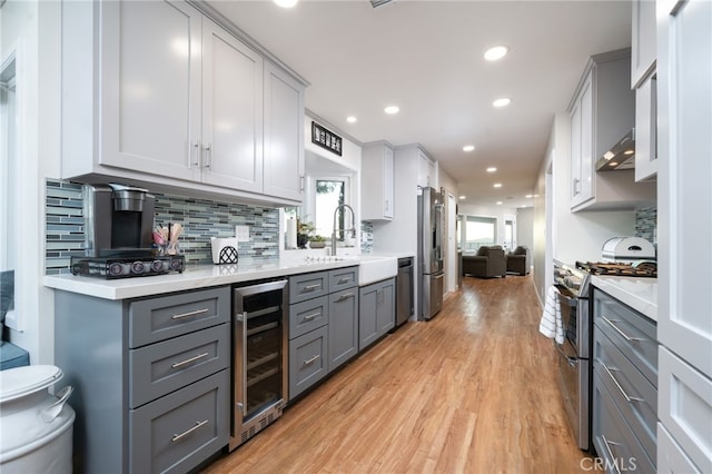 kitchen with gray cabinets, sink, wine cooler, and appliances with stainless steel finishes