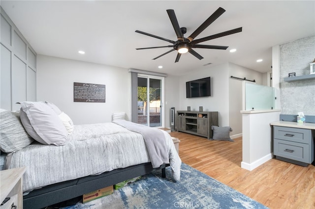 bedroom featuring access to exterior, ceiling fan, a barn door, and light wood-type flooring