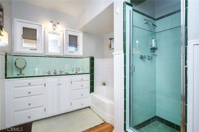 bathroom with plus walk in shower, hardwood / wood-style floors, and vanity