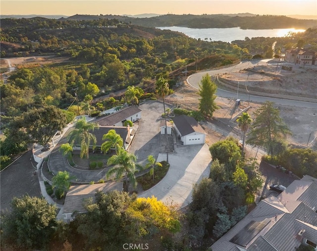 aerial view at dusk featuring a water view