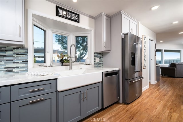 kitchen featuring appliances with stainless steel finishes, gray cabinets, and light hardwood / wood-style flooring