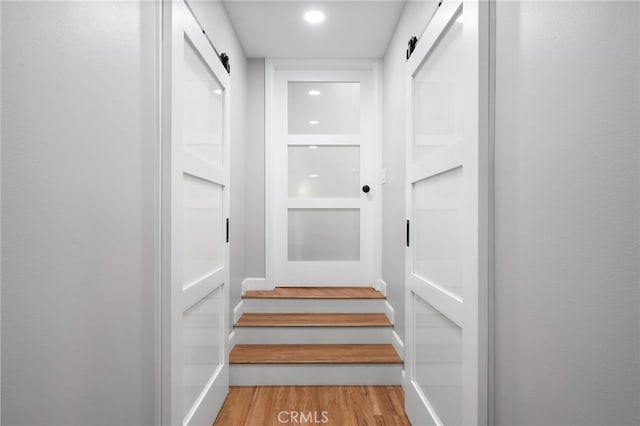 interior space with a barn door and light hardwood / wood-style flooring