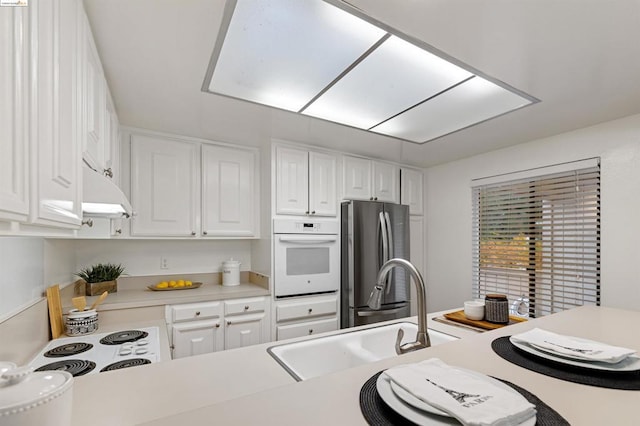 kitchen featuring white cabinetry and white appliances