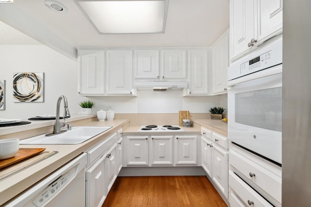 kitchen featuring white cabinetry, light hardwood / wood-style flooring, white appliances, and sink