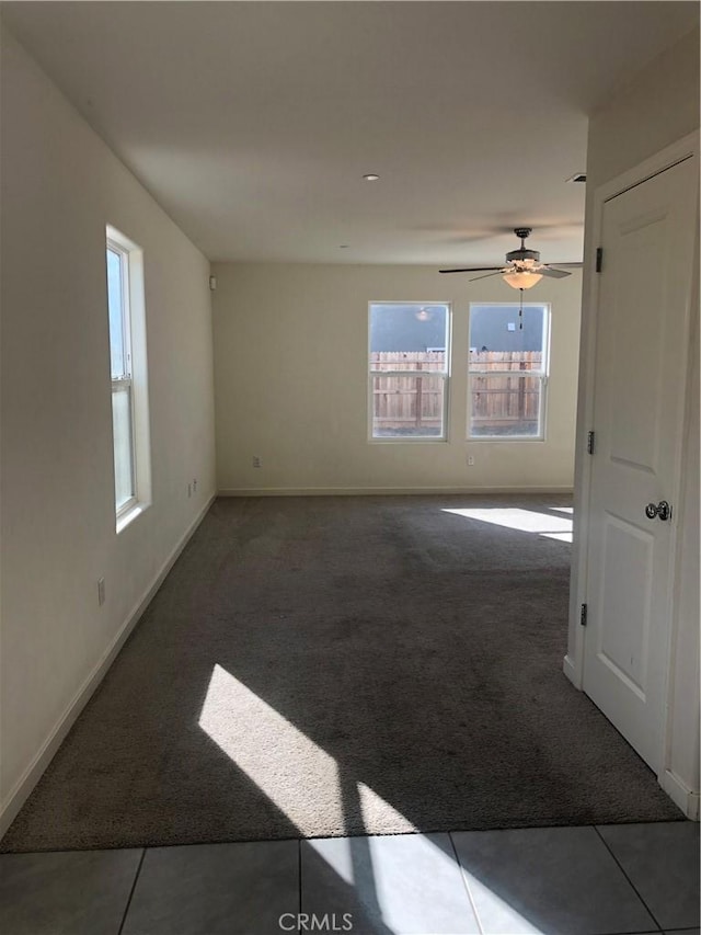 tiled spare room featuring ceiling fan