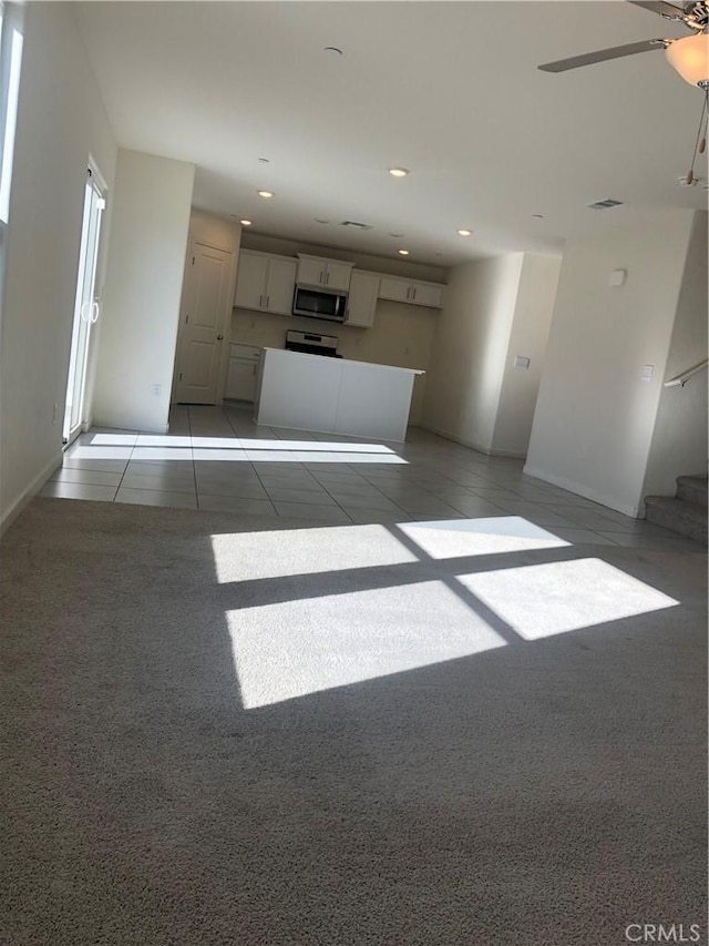 unfurnished living room with ceiling fan