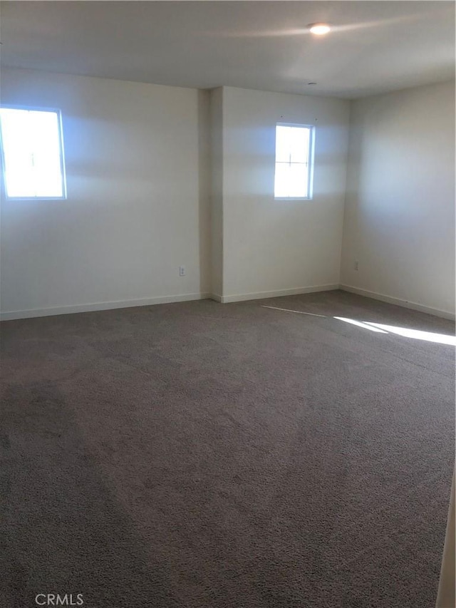 unfurnished room featuring dark colored carpet