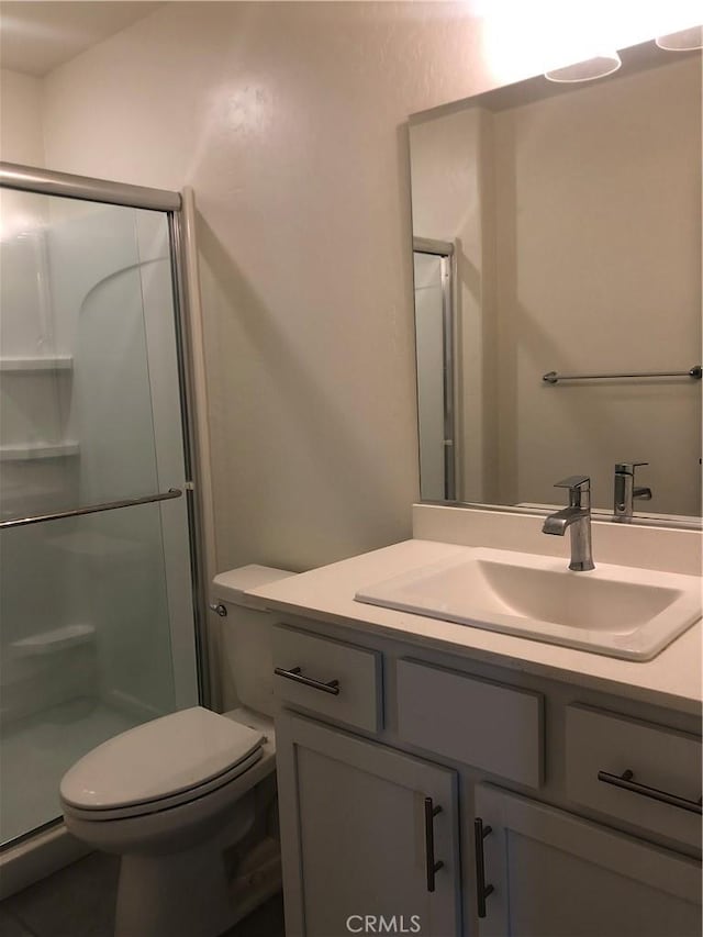 bathroom featuring toilet, an enclosed shower, and vanity