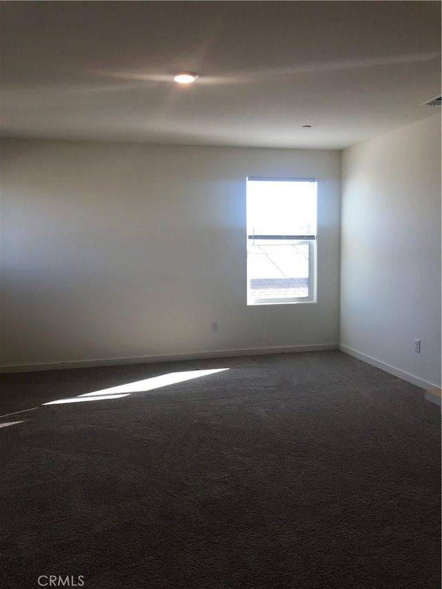 unfurnished room with dark carpet