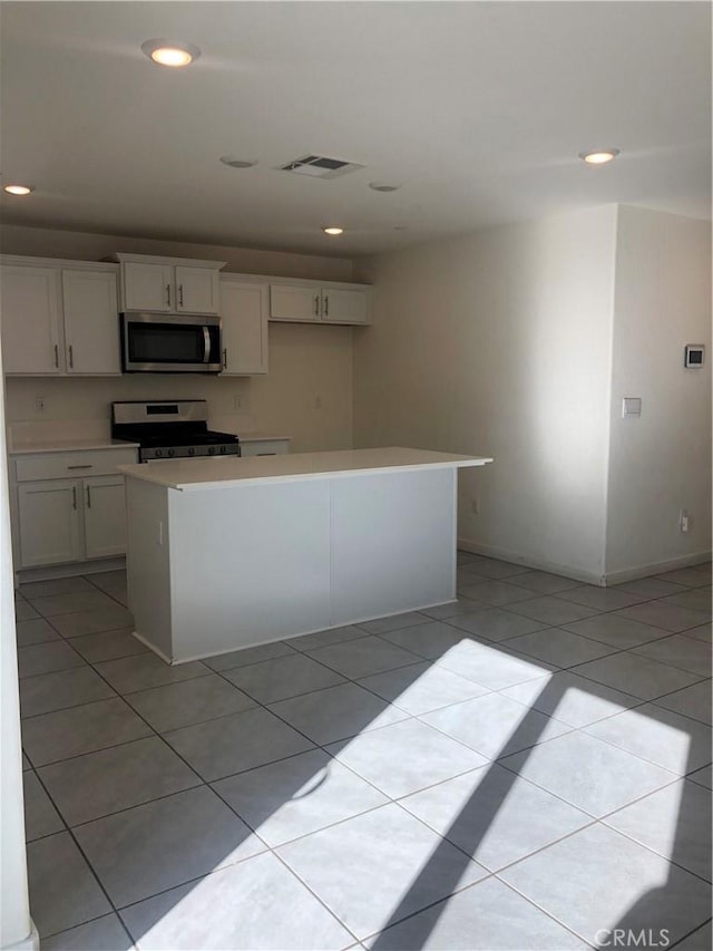 kitchen with white cabinetry, light tile patterned floors, a center island, and stainless steel appliances