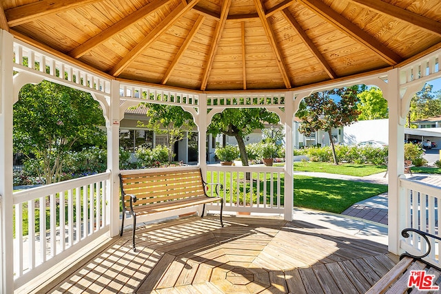 wooden terrace featuring a gazebo and a lawn